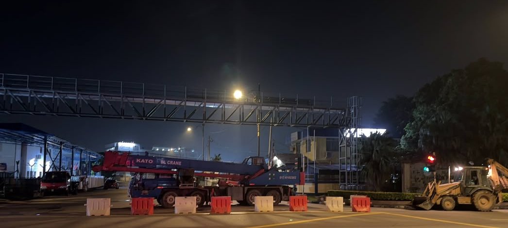 Night works at the road crossing, with barriers and crane in place